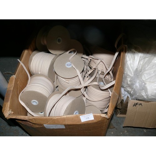 338 - LARGE BOX OF REELS OF FABRIC EDGING AND A BOX OF STUFFING READY CUT