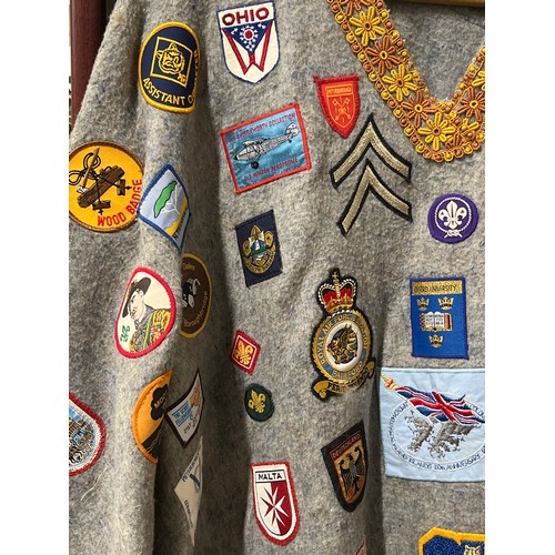 59 - VINTAGE CAMP PONCHO WITH A LARGE COLLECTION OF PATCH BADGES STITCHED ONTO IT, MANY SCOUTING TO INCLU... 