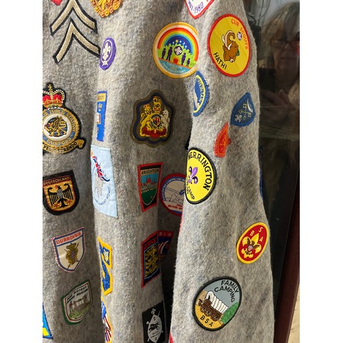 59 - VINTAGE CAMP PONCHO WITH A LARGE COLLECTION OF PATCH BADGES STITCHED ONTO IT, MANY SCOUTING TO INCLU... 