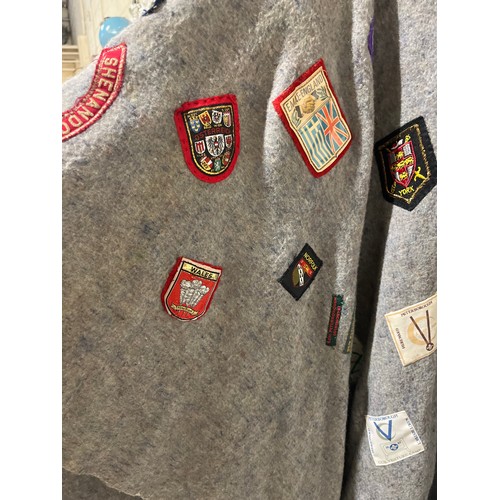 59 - VINTAGE CAMP PONCHO WITH A LARGE COLLECTION OF PATCH BADGES STITCHED ONTO IT, MANY SCOUTING TO INCLU... 