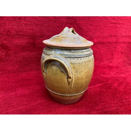 135 - Large earthenware storage jar with brown slip glaze. 35cm tall lidded.for flour or salt