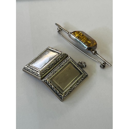 28 - A SILVER LOCKET AND BROOCH WITH BALTIC AMBER