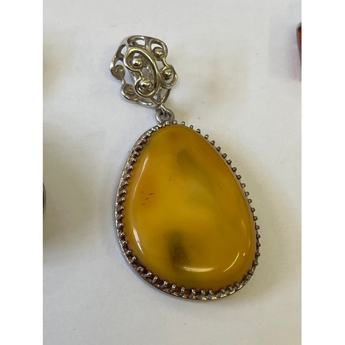 34 - A COLLECTION OF FOUR SOLID SILVER AND BALTIC AMBER PENDANTS