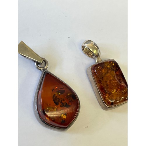 34 - A COLLECTION OF FOUR SOLID SILVER AND BALTIC AMBER PENDANTS