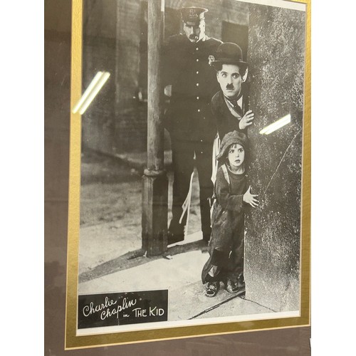 117 - LARGE FRAMED AND GLAZED PHOTOGRAPH OF CHARLIE CHAPLIN IN THE KID