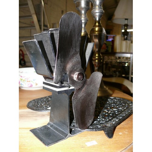 261 - A METAL HEAT POWERED STOVE FAN AND A PAIR OF CAST IRON TRIVETS