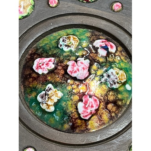 463 - MAHOGANY WALL PLAQUE WITH PINK AND GREEN ENAMEL ON COPPER DECORATION PLUS A WOODEN CARVED ROUND WALL... 