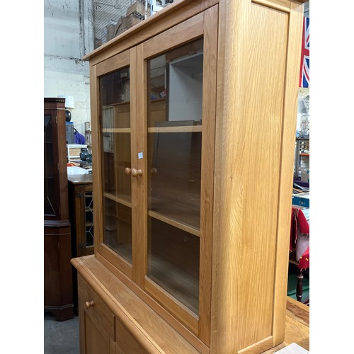 467 - LARGE LIGHT OAK DISPLAY CABINET WITH GLAZED DOORS TO TOP AND CUPBOARD PLUS 2 DRAWERS BELOW