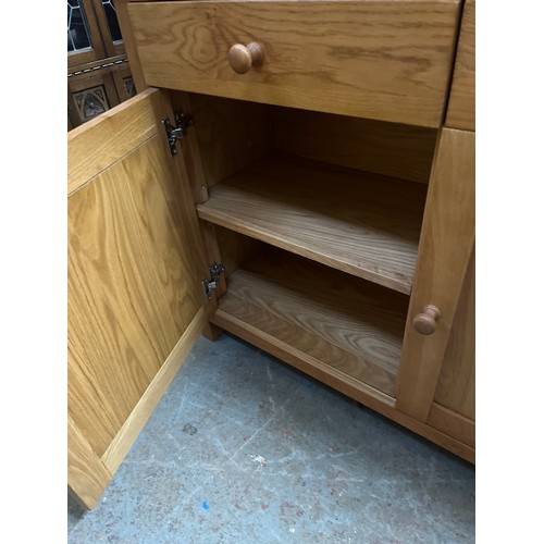 467 - LARGE LIGHT OAK DISPLAY CABINET WITH GLAZED DOORS TO TOP AND CUPBOARD PLUS 2 DRAWERS BELOW