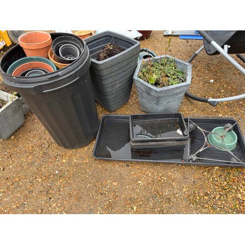 517 - LARGE COLLECTION OF PLASTIC PLANT POTS WITH BAGS OF COMPOST AND WATERING CAN