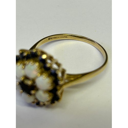 23 - A SAPPHIRE AND BLACK OPAL MULTI COLOURS 9ct GOLD FLOWER PATTERN WITH SAPPHIRE CENTRE AND ALL AROUND ... 