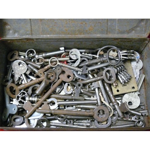 217 - TREASURE CHEST TIN FULL OF VINTAGE KEYS AND A LARGE OLD BRASS KEY BOTTLE OPENER