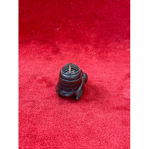 47 - Japanese boxwood Netsuke, finely carved in the form of a small figure crouching beneath a larger bōg... 