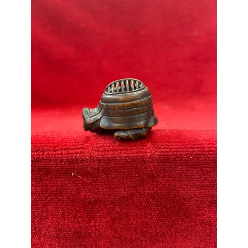 47 - Japanese boxwood Netsuke, finely carved in the form of a small figure crouching beneath a larger bōg... 