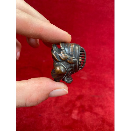 47 - Japanese boxwood Netsuke, finely carved in the form of a small figure crouching beneath a larger bōg... 