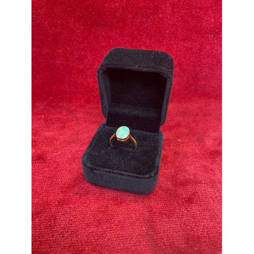 63 - A Vintage 18ct gold ring set with a good sized opal cabochon (12mm x 8mm). Good depth of colour. Siz... 