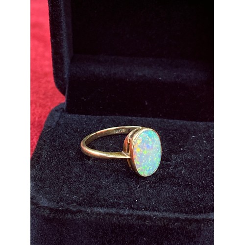 63 - A Vintage 18ct gold ring set with a good sized opal cabochon (12mm x 8mm). Good depth of colour. Siz... 