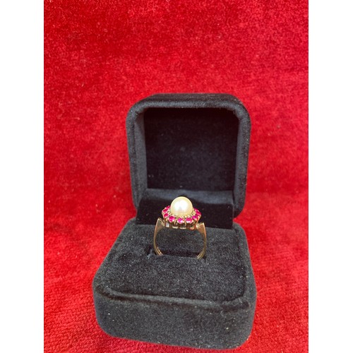 65 - A beautiful vintage 9ct gold dress ring set with a large pearl surrounded by 12 rubies. London hallm... 