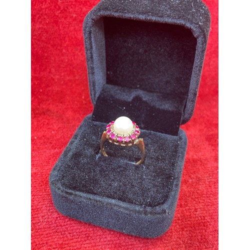 65 - A beautiful vintage 9ct gold dress ring set with a large pearl surrounded by 12 rubies. London hallm... 
