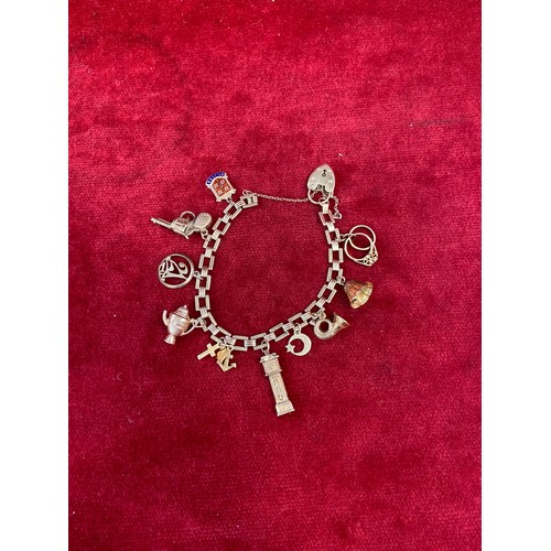 67 - A vintage 9ct gold charm bracelet with square chain links, heart padlock clasp and 10 charms (pistol... 