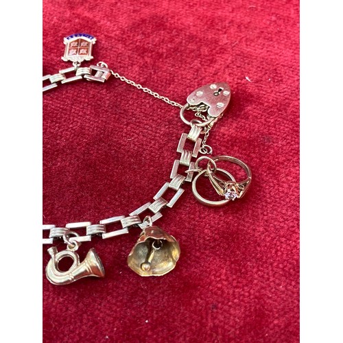 67 - A vintage 9ct gold charm bracelet with square chain links, heart padlock clasp and 10 charms (pistol... 