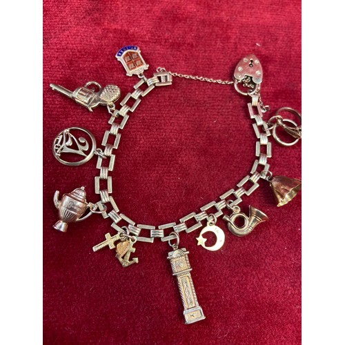 67 - A vintage 9ct gold charm bracelet with square chain links, heart padlock clasp and 10 charms (pistol... 