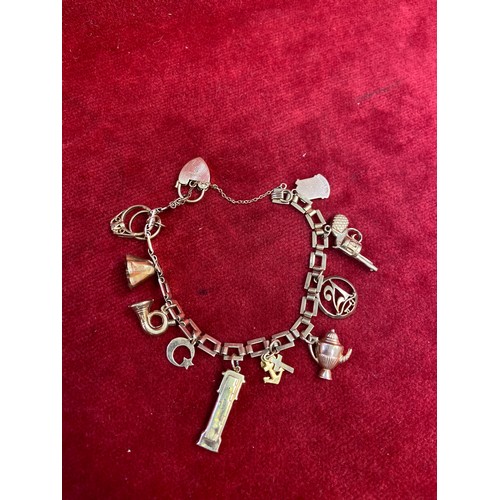 67 - A vintage 9ct gold charm bracelet with square chain links, heart padlock clasp and 10 charms (pistol... 