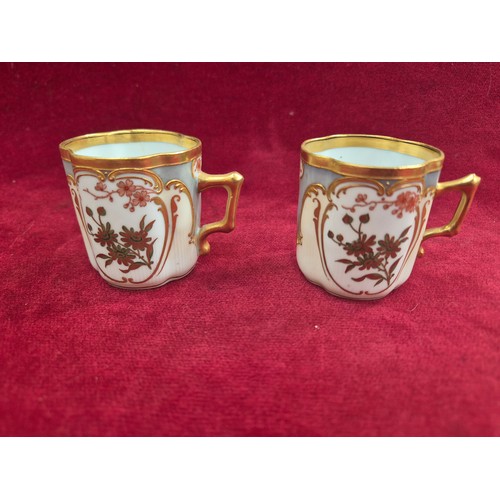120 - A pair of pretty antique coffee cans and saucers, with hand painted floral and gilt decoration, the ... 