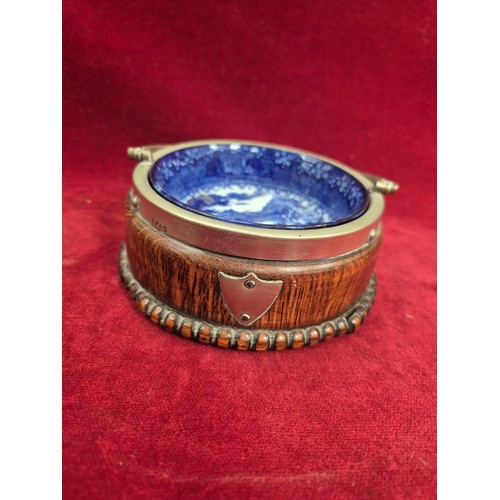 131 - A Victorian flow blue 'Jenny Lind' dish in an oak and E.P.N.S. swing handled table coaster/holder.
T... 