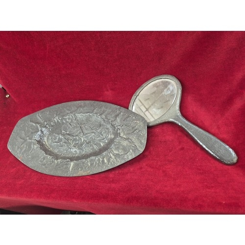 134 - Arts & Crafts pewter dressing table tray and matching hand mirror with embossed floral decoration.