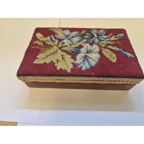 94G - A small wooden box with a needlepoint lid, embroidered with blue Lillies on a red ground.