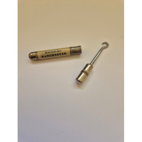 94B - Small advertising pocket button hook. White metal tube with screw action hook stored inside, the cel... 