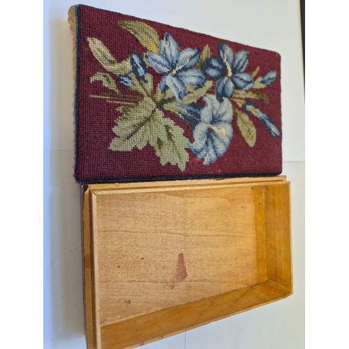 39 - A small wooden box with a needlepoint lid, embroidered with blue Lillies on a red ground.