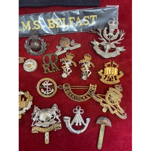 44 - Collection of military cap badges and naval ribbons/slides. Including army, marines and RAF brass ba... 