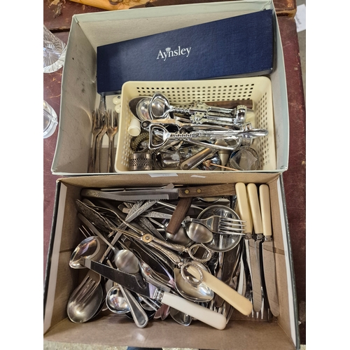335 - 2 boxes of mixed cutlery to include an Aynsley cake slice, corkscrews, napkin rings, tongs, butter k... 
