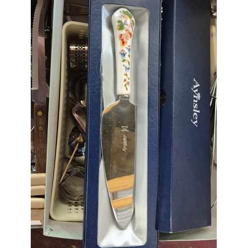 335 - 2 boxes of mixed cutlery to include an Aynsley cake slice, corkscrews, napkin rings, tongs, butter k... 