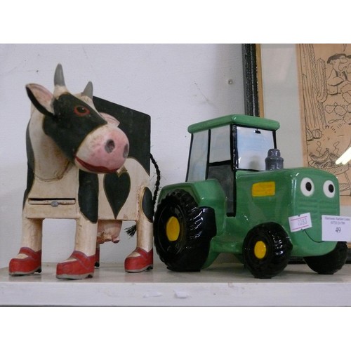 49 - CERAMIC TRACTOR MONEY BOX (JOHN DEERE) AND A CARVED WOODEN COW MONEY BOX.
