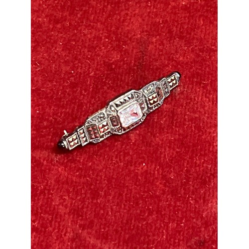 22 - An Art Deco style silver and marcasite brooch with central diamante and French jet cabochon tips