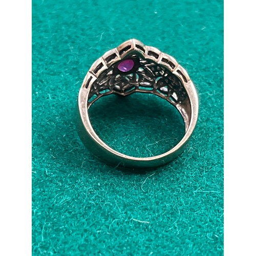 36 - A renaissance style 9ct gold ring set with a central oval cut  ruby surrounded by diamond chips in a... 