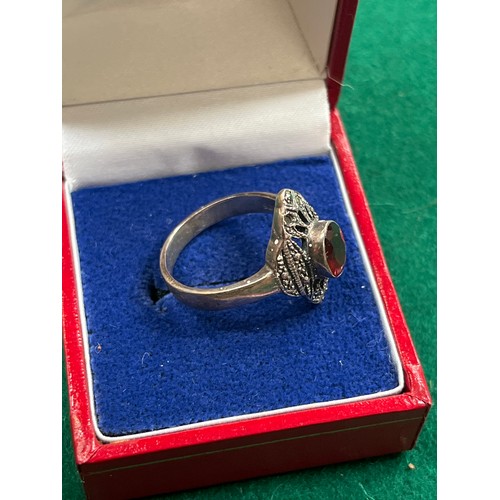 40 - An Art Deco silver ring set with an oval cut garnet & marcasite - size O/P