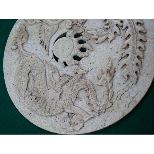 57 - A large Chinese stone disc (26cm dia) depicting a dragon and a phoenix - in Chinese culture depicts ... 