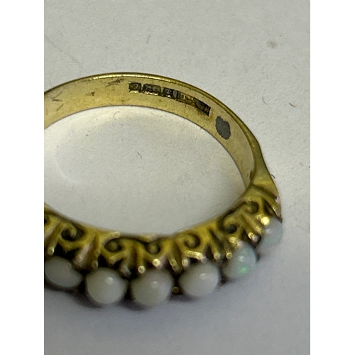41 - A vintage gold on sterling silver ring with a gallery set with 7 white opals. Hallmarked Birmingham ... 
