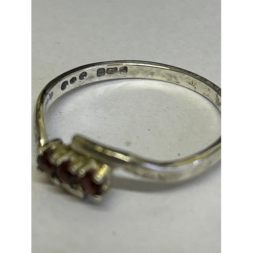 44 - Two vintage sterling silver rings, one in crossover style with 3 garnet stones hallmarked Sheffield ... 