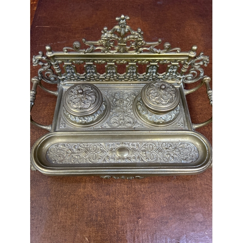 326 - An early 20th Century solid brass desk stand, with raised gallery back. The inkwells with amber glas... 