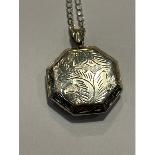94 - A sterling silver chain with sterling silver locket engraved with a scrolling leaf pattern