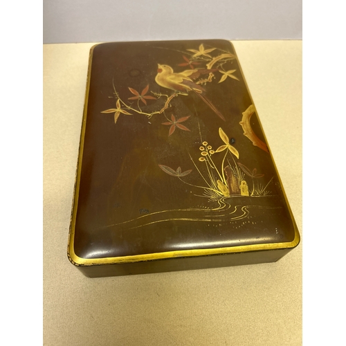 140 - An early 20th Century Japanese glove or scarf box in chestnut lacquer with gilt design of a bird on ... 