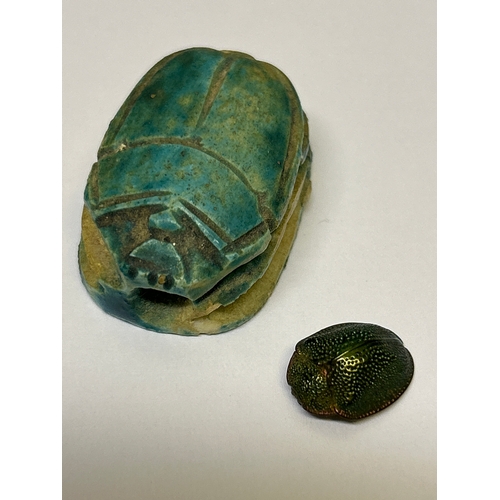 142 - Two scarab beetle pieces, one in ceramic with Egyptian Hieroglyphs, the other in patinated gilt meta... 