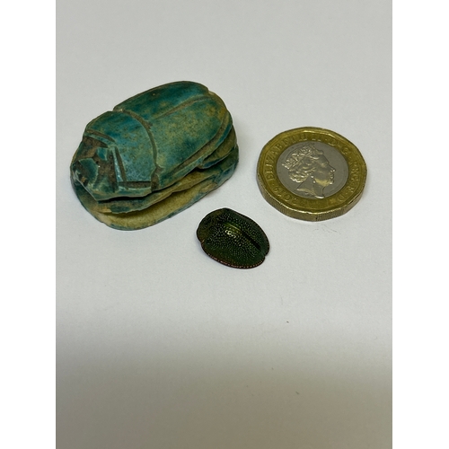 142 - Two scarab beetle pieces, one in ceramic with Egyptian Hieroglyphs, the other in patinated gilt meta... 