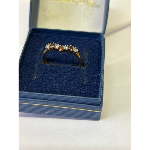 119 - A 9ct gold wishbone ring set with cubic zirconia and garnets. Size M , 1.3 grams