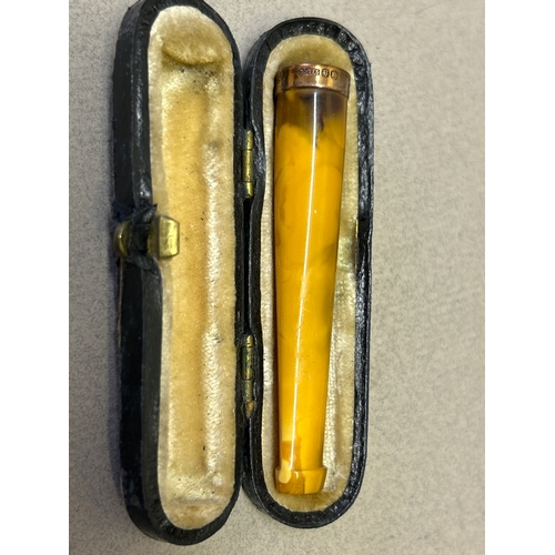 123 - An amber cheroot holder with a 9ct gold tip hallmarked London 1922 with original leather case.